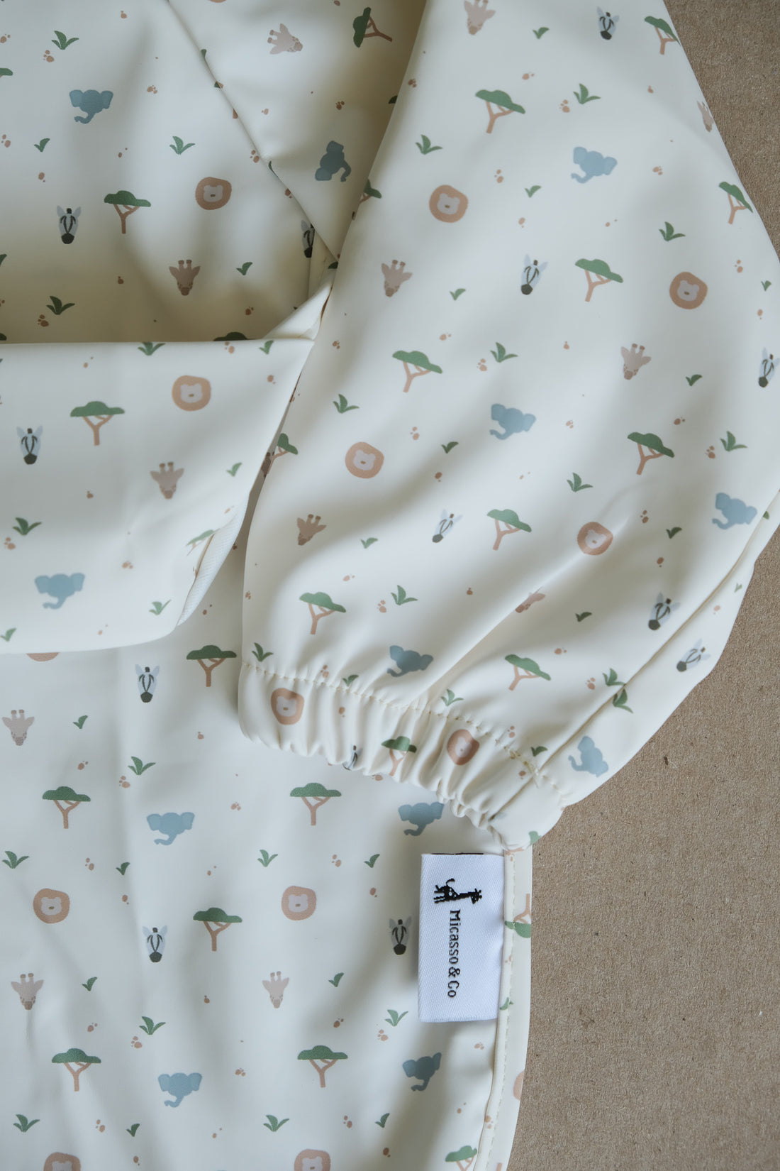 Bavette à manches longues avec pochette intégrée qui attrape la nourriture