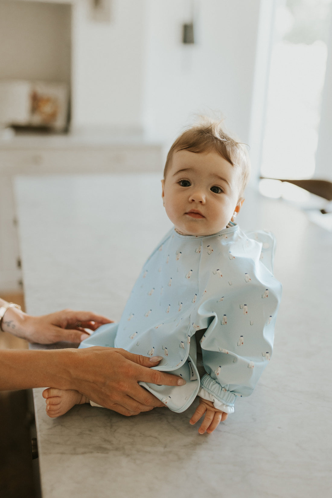 Bébé qui apprend à manger seul dans sa chaise haute pendant la diversification alimentaire DME
