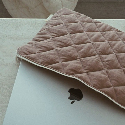 Détail du capitonnage chic de la pochette matelassée pour ordinateur
