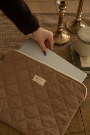Femme tenant une pochette matelassée pour ordinateur fabriquée au Québec
